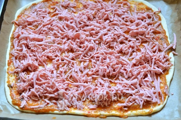 Тесто смазать баклажанной икрой и посыпать тертой колбасой
